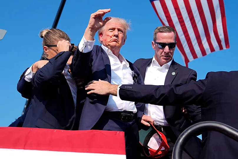 Trump is surrounded by US Secret Service agents as he leaves the stage at a campaign rally, Saturday, July 13, 2024.