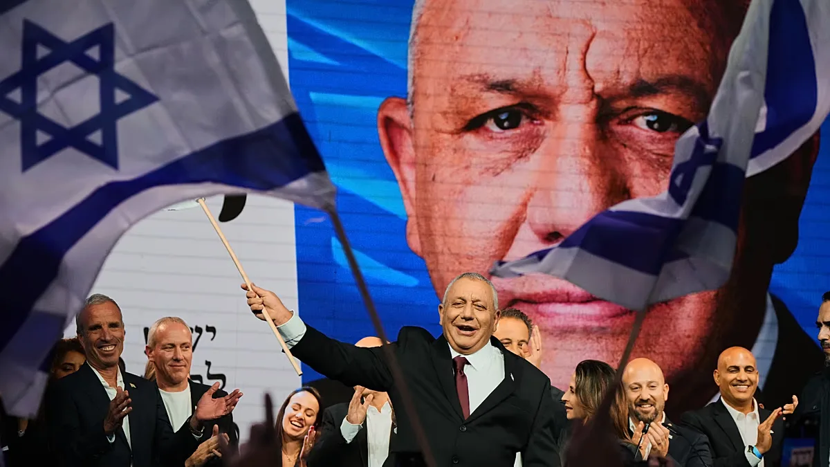 Gadi Eisenkot, leader of the Yashar ("Straight") party, waves an Israeli flag onstage following the release of the first exit poll results. 28 October 2026