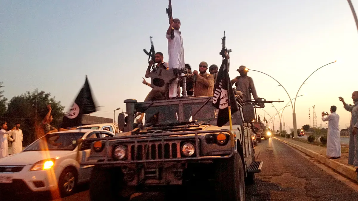 Fighters from the "Islamic State" group parade in an armoured vehicle seized from Iraqi security forces in Mosul, Iraq, on 23 June 2014