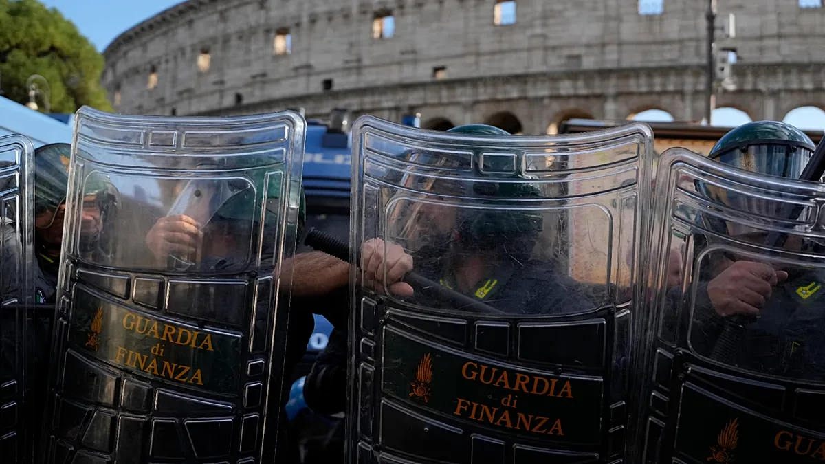 Italian riot police look on as anti-war activists protest against rearmament and Italy's role in wars outside the Colosseum in Rome, Saturday 24 Oct 2026.