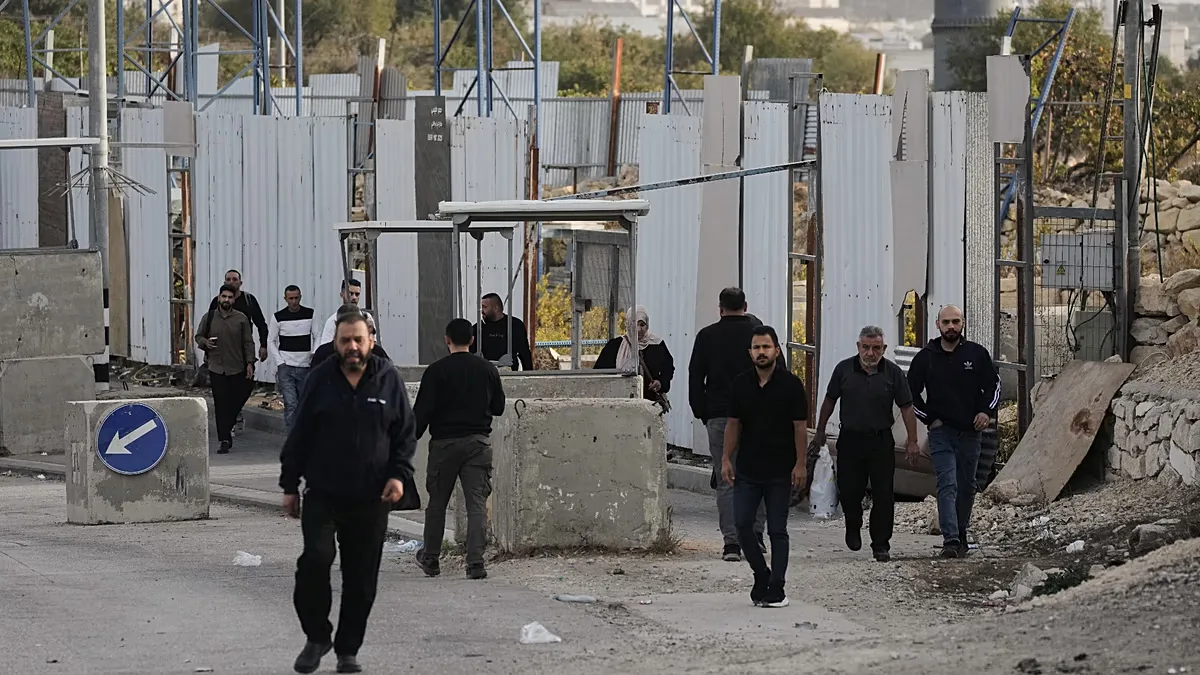Palestinians cross on foot past a military gate closed to vehicles during an Israeli army operation in Hebron in the occupied West Bank