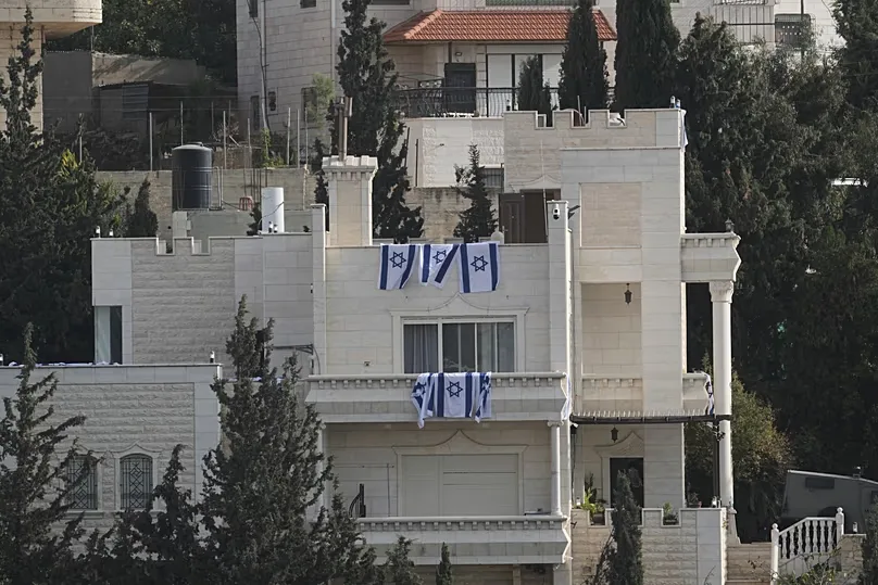 Israeli flags hang from a house belonging to Palestinian residents during an Israeli army operation in Hebron, in the occupied West Bank, Saturday, Oct. 24, 2026