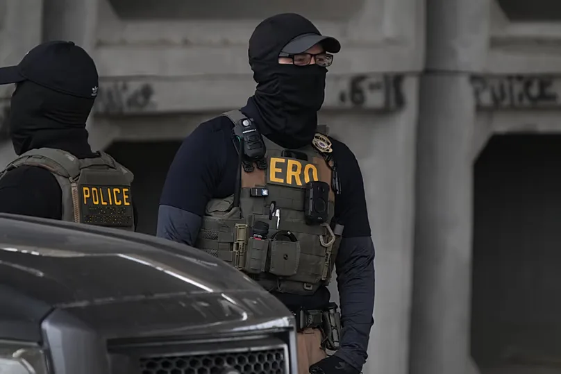 An Immigration and Customs Enforcement officer walks the scene where a man was shot in his vehicle by an ICE officer, Sunday, Sept. 20, 2026, in Austin, Texas