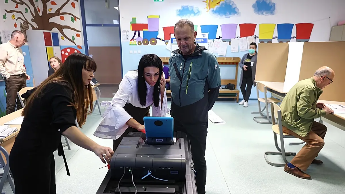 Election officials check an electronic ballot box during the general election in Sarajevo, Bosnia, Sunday, Oct. 4, 2026. (AP Photo/Armin Durgut)