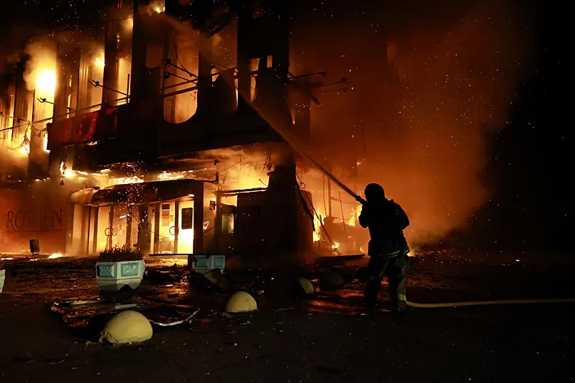 A rescuer extinguishes a fire at the Intrade shopping centre after a Russian drone strike on Zaporizhzhzhia, Ukraine, Monday, 21 September 2026.
