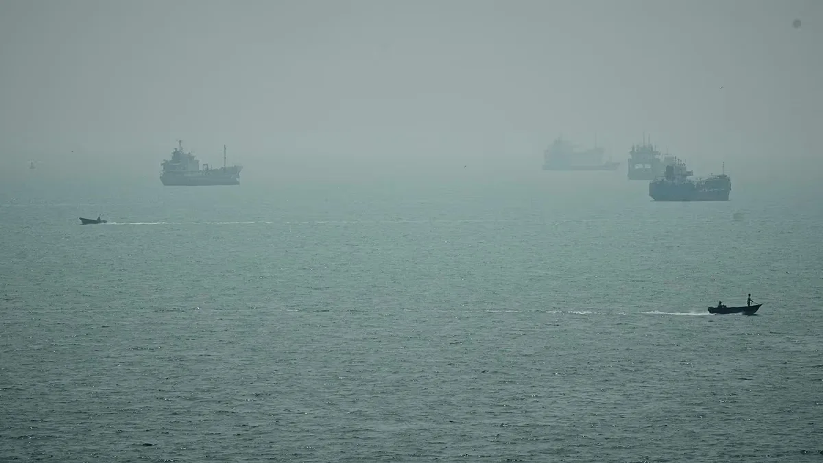 Motorboats travel past commercial vessels anchored amid haze in the Strait of Hormuz off Bandar Abbas, Iran, Monday, Sept. 7, 2026.