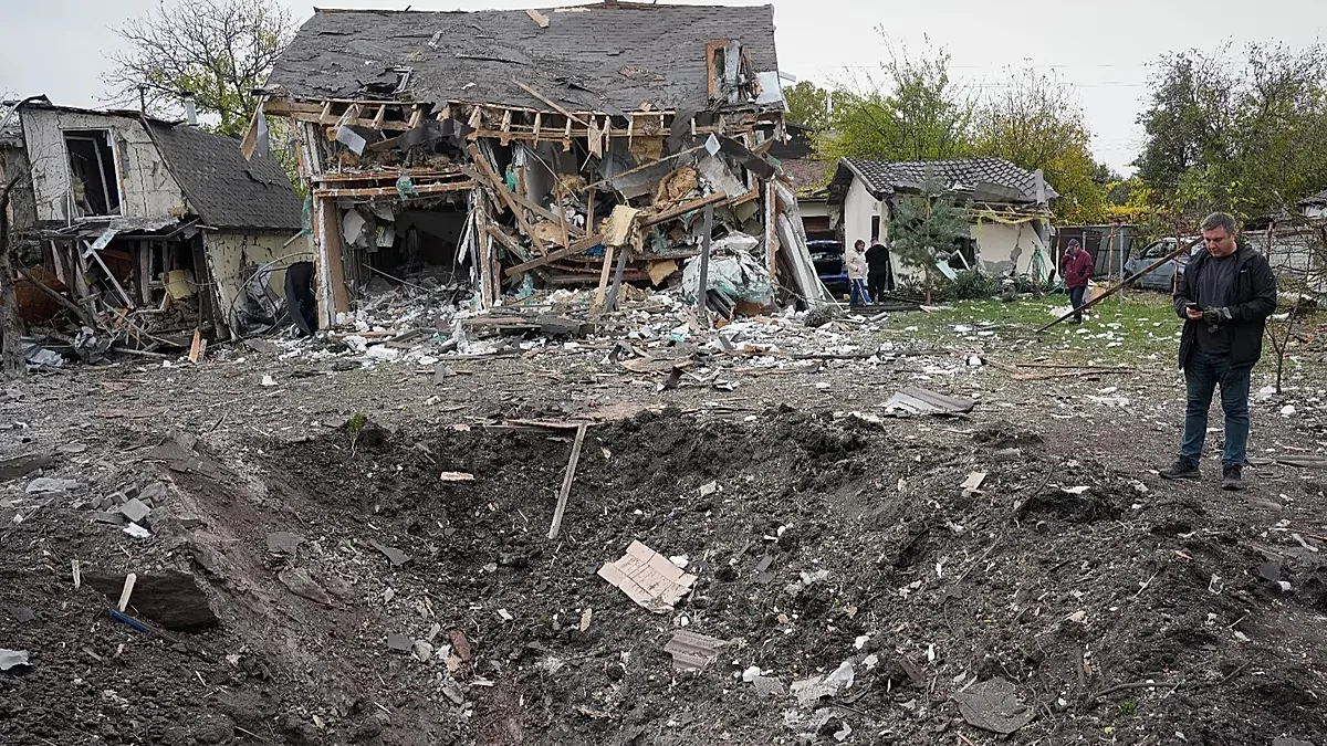 A man looks at a crater after a Russian missile strike in Kyiv, Ukraine, Thursday, Oct. 22, 2026.