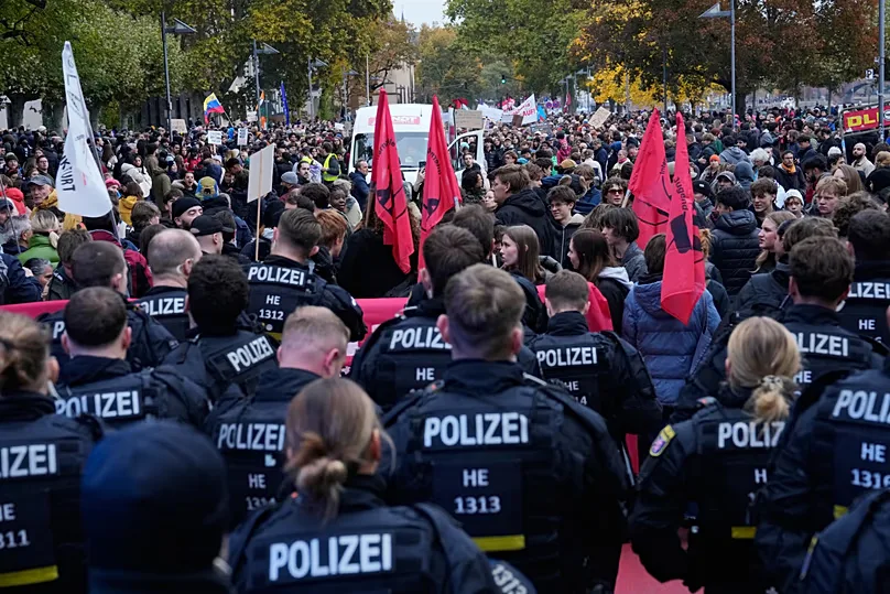 Police officers stand in front of demonstrators during a protest under the slogan "Gen Z Takes Care of It" in Berlin, Germany, Saturday, Oct. 31, 2026.