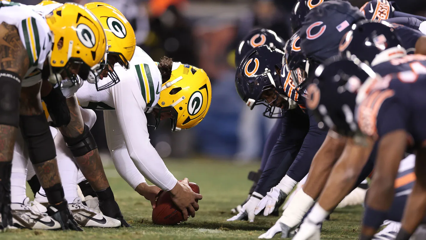 NFL football players line up to snap the ball.