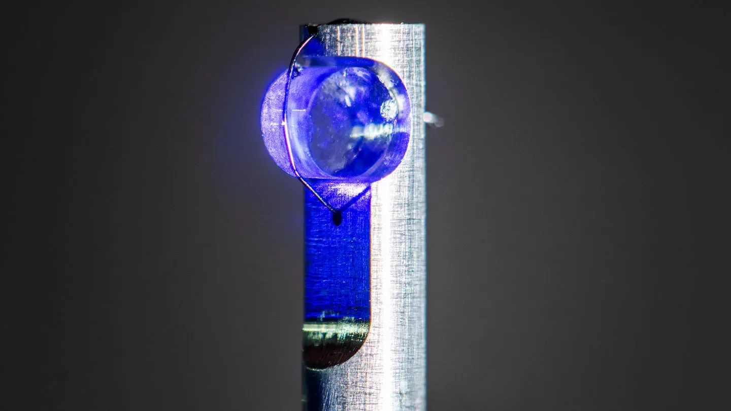 A translucent blue cylindrical crystal mounted on a post