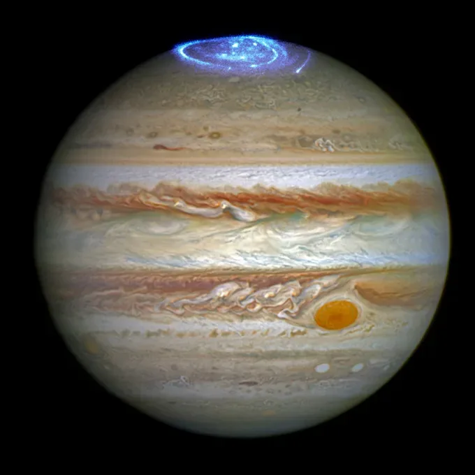 Jupiter is shown with a blue aurora.