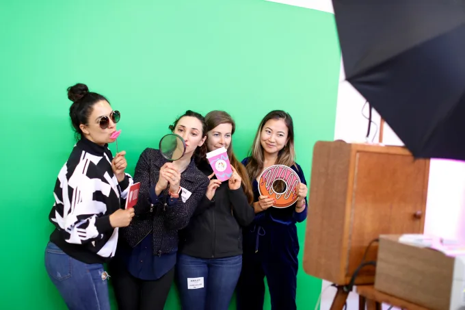 People pose in front of a green screen at TechCrunch Disrupt SF 2019's Women in Tech(Crunch) reception